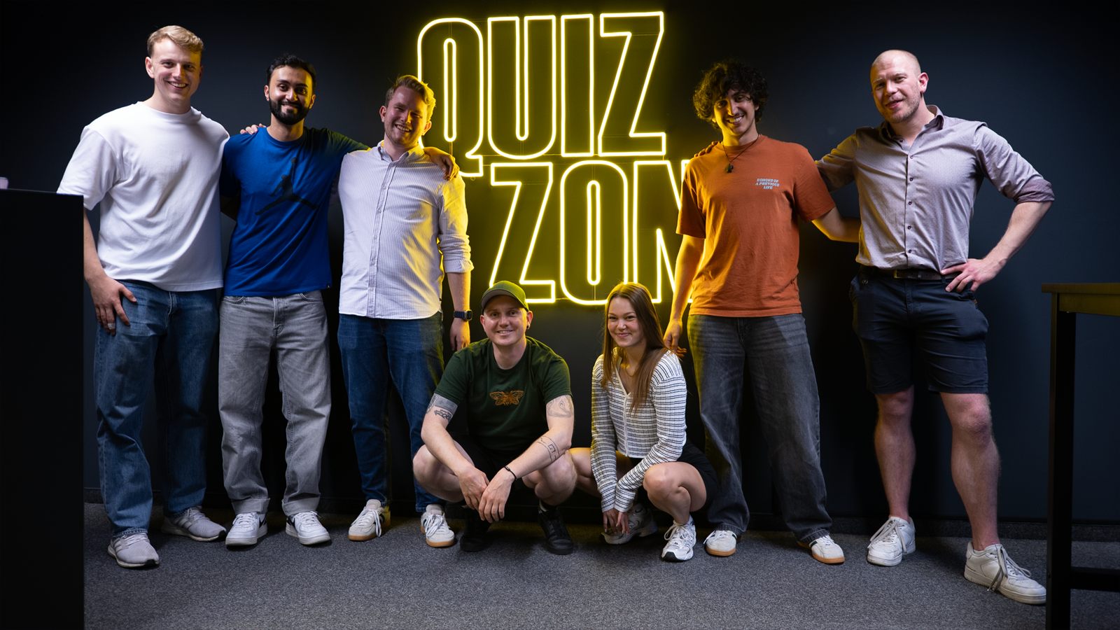 Firmenteam vor der QUIZ ZONE Neon-Schrift in Nürnberg